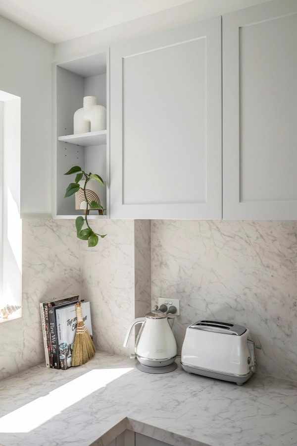 This is an example of a small beach style u-shaped kitchen pantry in Sydney with a drop-in sink, shaker cabinets, grey cabinets, tile benchtops, multi-coloured splashback, porcelain splashback, stainless steel appliances, light hardwood floors, a peninsula, beige floor and multi-coloured benchtop.