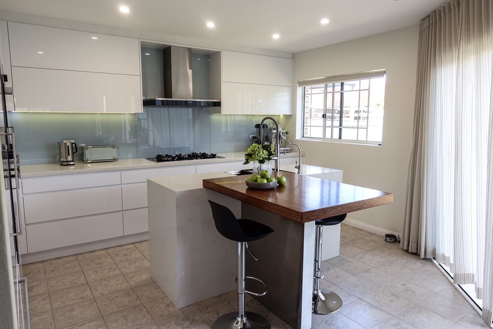 Inspiration for a mid-sized contemporary l-shaped eat-in kitchen in Sydney with an undermount sink, raised-panel cabinets, white cabinets, quartz benchtops, blue splashback, glass sheet splashback, stainless steel appliances, ceramic floors, with island and grey floor.