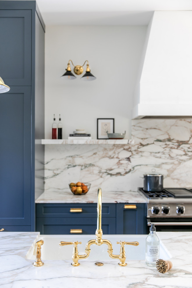 Design ideas for a mid-sized transitional galley open plan kitchen in Calgary with a double-bowl sink, shaker cabinets, blue cabinets, marble benchtops, multi-coloured splashback, marble splashback, panelled appliances, light hardwood floors, with island and multi-coloured benchtop.