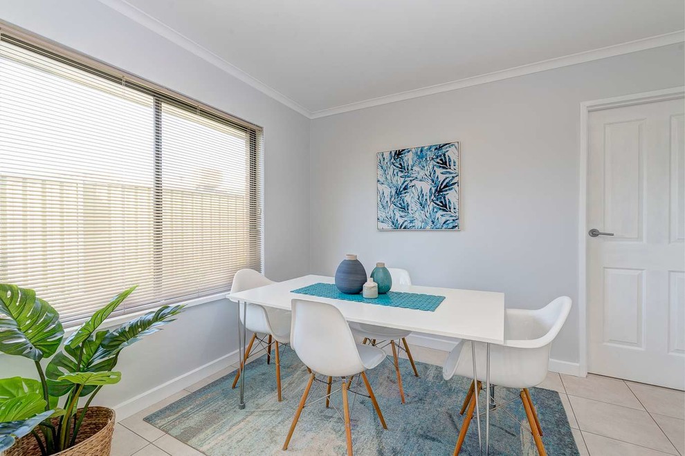 Design ideas for a beach style dining room in Adelaide with grey walls and beige floor.