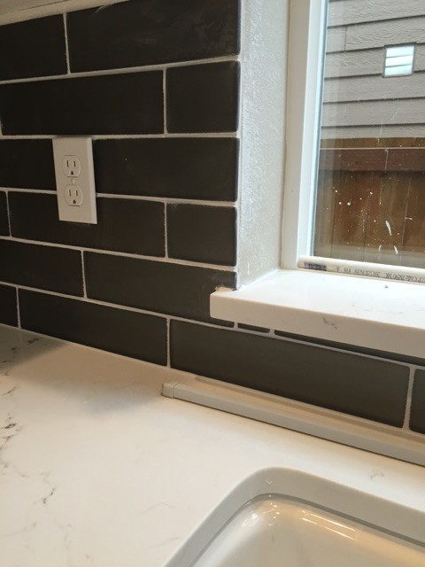 Example of a mid-sized transitional single-wall medium tone wood floor eat-in kitchen design in Seattle with an undermount sink, flat-panel cabinets, dark wood cabinets, quartz countertops, gray backsplash, glass tile backsplash, stainless steel appliances and an island