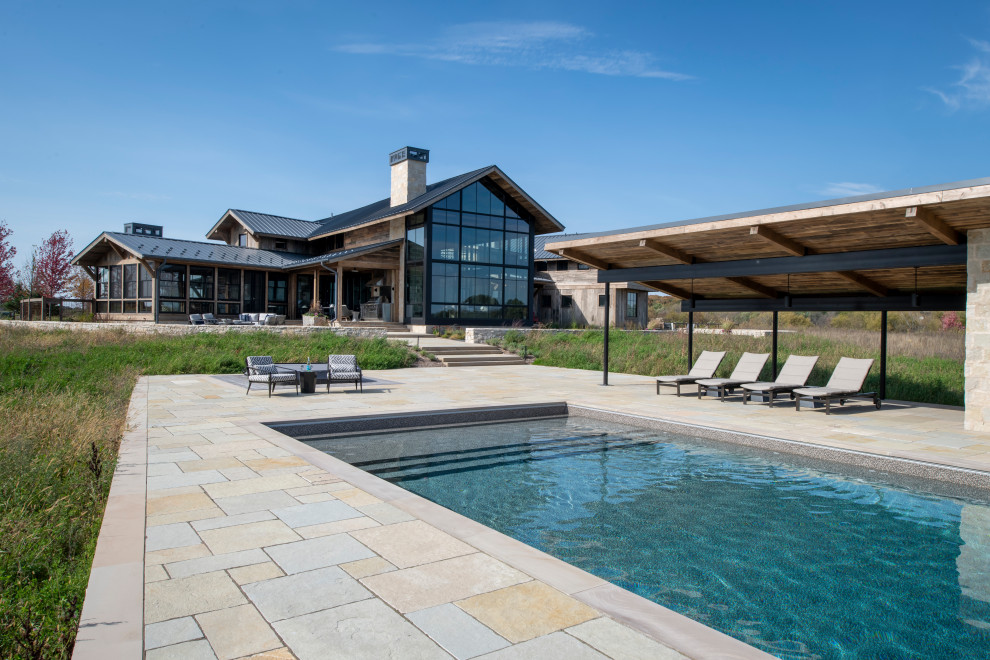 Ispirazione per una grande piscina naturale rustica rettangolare dietro casa con una dépendance a bordo piscina e pavimentazioni in pietra naturale