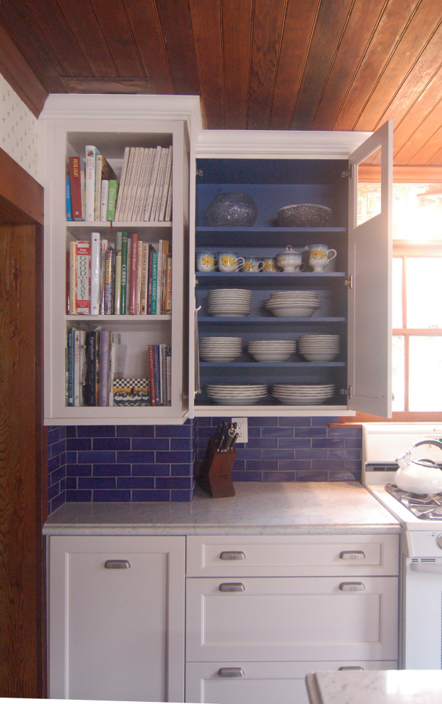 Photo of a small country galley eat-in kitchen in San Luis Obispo with shaker cabinets, blue cabinets, marble benchtops, blue splashback, subway tile splashback, white appliances, vinyl floors, with island, blue floor, white benchtop and timber.