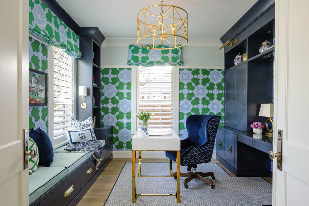 Photo of a transitional study room in Portland with green walls, medium hardwood floors, a freestanding desk, brown floor and wallpaper.