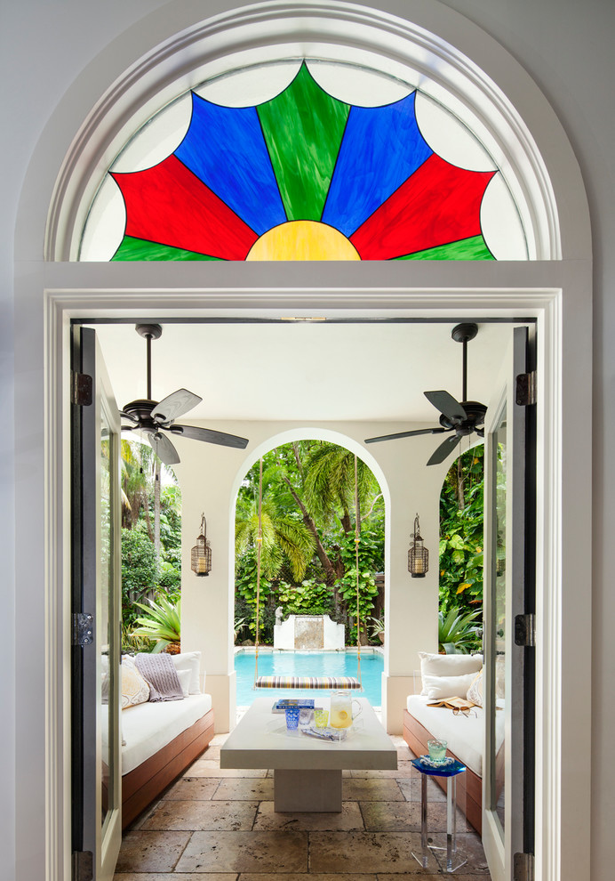Photo of a tropical open concept family room in Miami with a wall-mounted tv.
