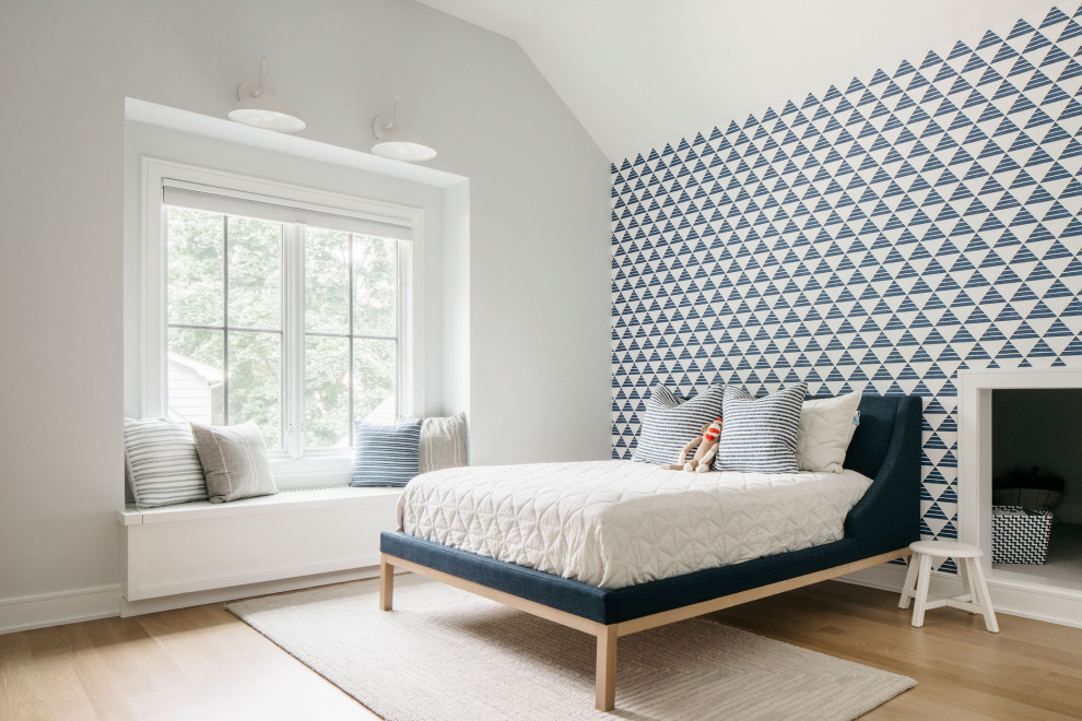 Photo of a medium sized vintage gender neutral children’s room in Chicago with white walls, a vaulted ceiling and wallpapered walls.
