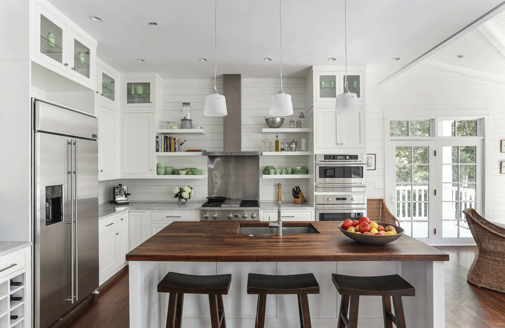 Design ideas for a beach style l-shaped eat-in kitchen in Charleston with a single-bowl sink, shaker cabinets, white cabinets, wood benchtops and stainless steel appliances.