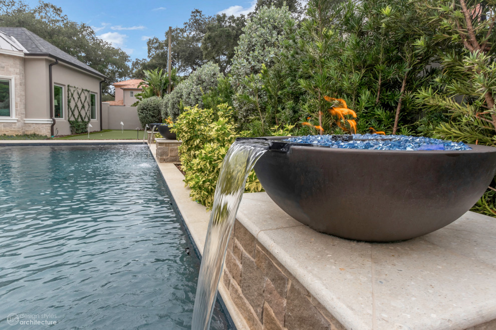 Esempio di una grande piscina monocorsia chic personalizzata dietro casa con fontane e pavimentazioni in cemento