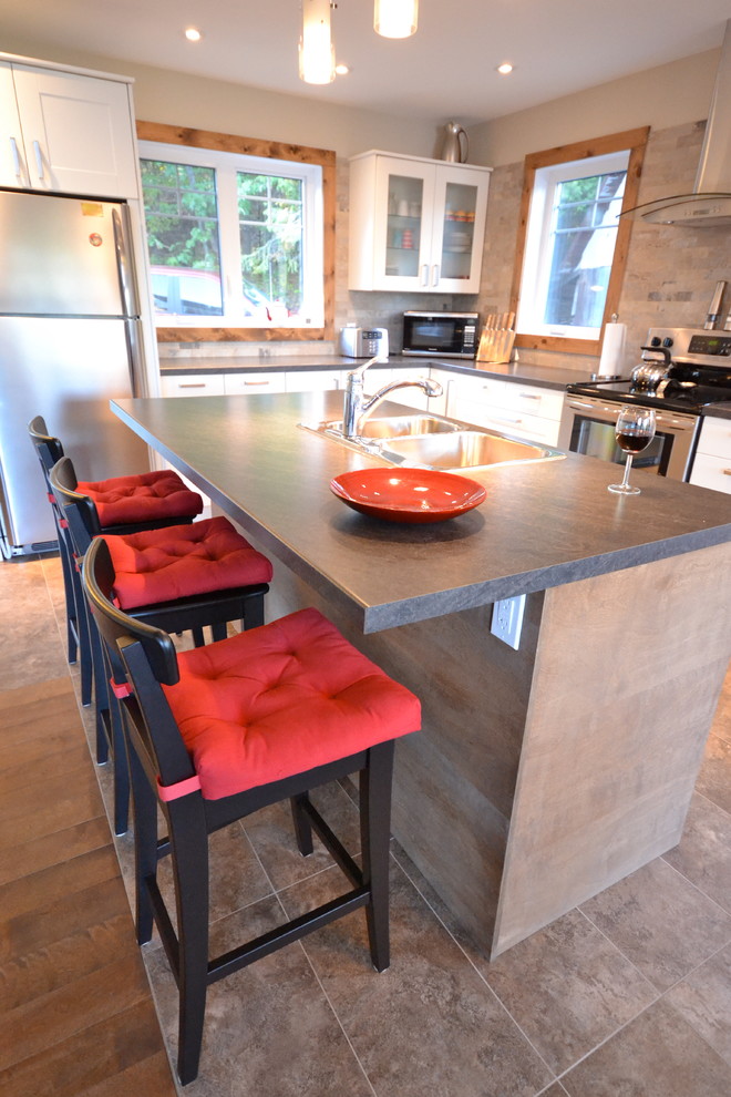 Mid-sized elegant l-shaped ceramic tile and beige floor eat-in kitchen photo in Ottawa with a double-bowl sink, shaker cabinets, white cabinets, soapstone countertops, beige backsplash, stone tile backsplash, stainless steel appliances and an island