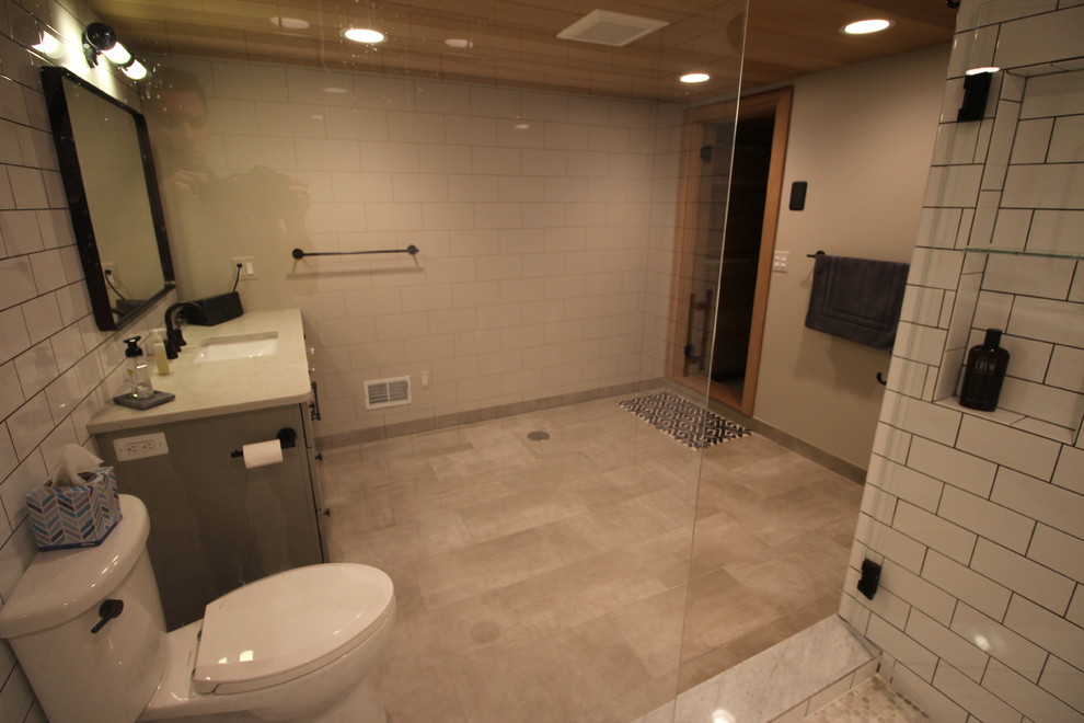 Large transitional white tile and ceramic tile porcelain tile alcove shower photo in Detroit with raised-panel cabinets, gray cabinets, a two-piece toilet, gray walls, an undermount sink and quartz countertops