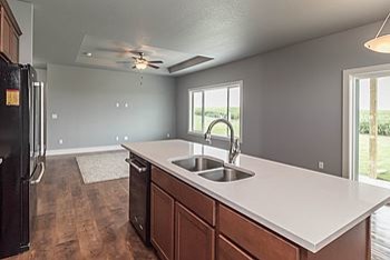 Eat-in kitchen - mid-sized transitional l-shaped medium tone wood floor eat-in kitchen idea with an undermount sink, recessed-panel cabinets, medium tone wood cabinets, quartz countertops, black appliances and an island