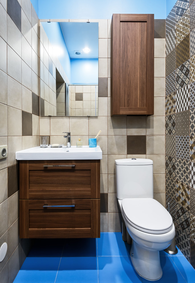 Small transitional powder room in Moscow with shaker cabinets, dark wood cabinets, a two-piece toilet, beige tile, brown tile, blue tile and blue floor.