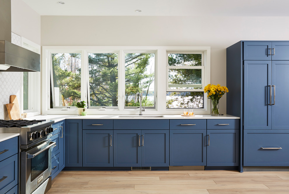 Immagine di una cucina scandinava di medie dimensioni con ante blu e top bianco