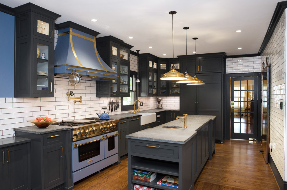 Inspiration for an arts and crafts l-shaped eat-in kitchen in Charlotte with a farmhouse sink, shaker cabinets, grey cabinets, soapstone benchtops, white splashback, subway tile splashback, coloured appliances, dark hardwood floors, with island, brown floor and grey benchtop.