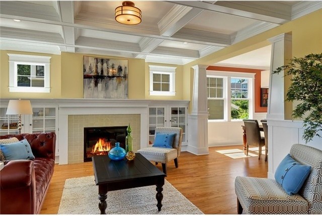 Mid-sized arts and crafts formal enclosed living room in Seattle with yellow walls, medium hardwood floors, a standard fireplace, a tile fireplace surround, no tv and brown floor.