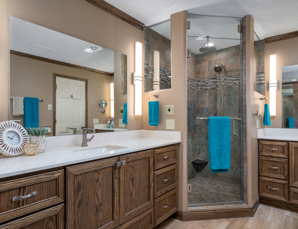 Mid-sized country master bathroom in Minneapolis with recessed-panel cabinets, brown cabinets, a corner tub, a corner shower, a bidet, beige tile, porcelain tile, beige walls, porcelain floors, an undermount sink, quartzite benchtops, beige floor, a hinged shower door and beige benchtops.