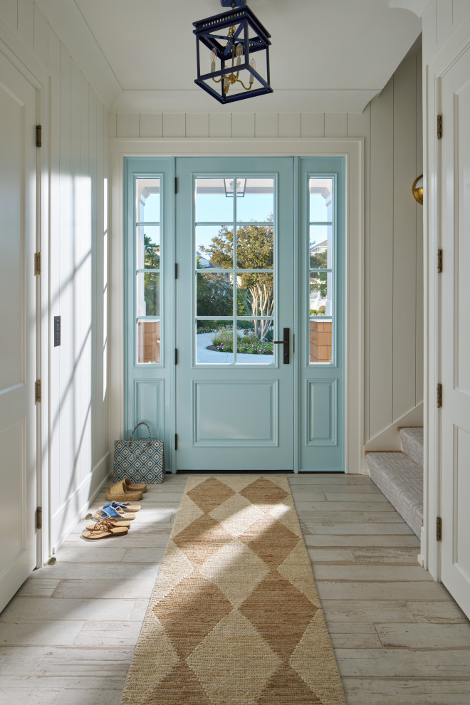 Huge beach style front door photo with white walls and a blue front door