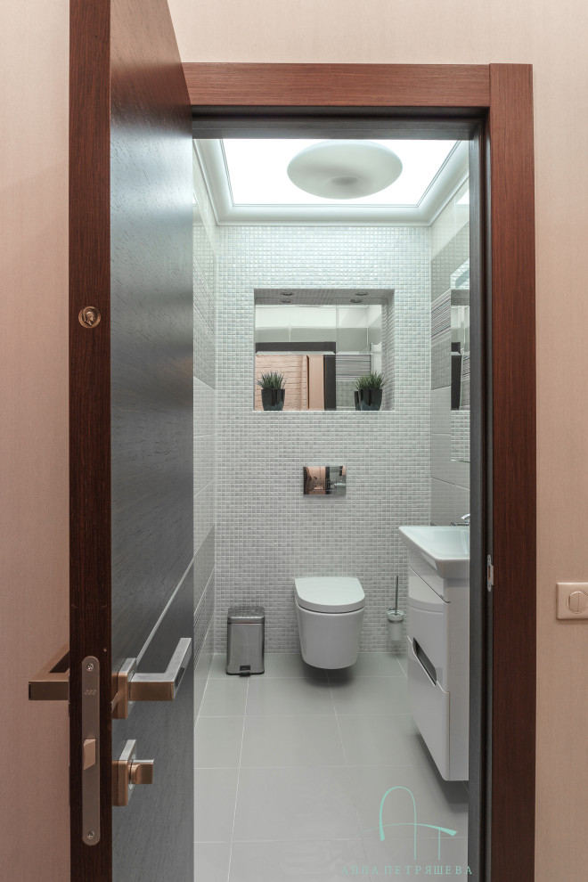 Design ideas for a medium sized contemporary cloakroom in Other with flat-panel cabinets, white cabinets, a wall mounted toilet, white tiles, porcelain tiles, porcelain flooring, a built-in sink, a floating vanity unit and a wallpapered ceiling.