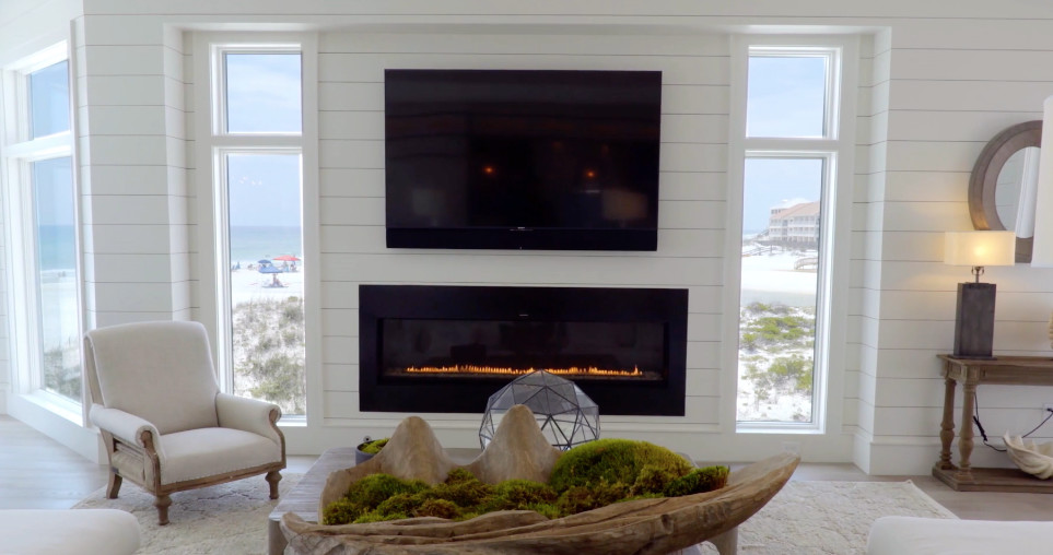 Design ideas for a beach style open concept living room in Miami with white walls, light hardwood floors, a ribbon fireplace, a metal fireplace surround and a wall-mounted tv.