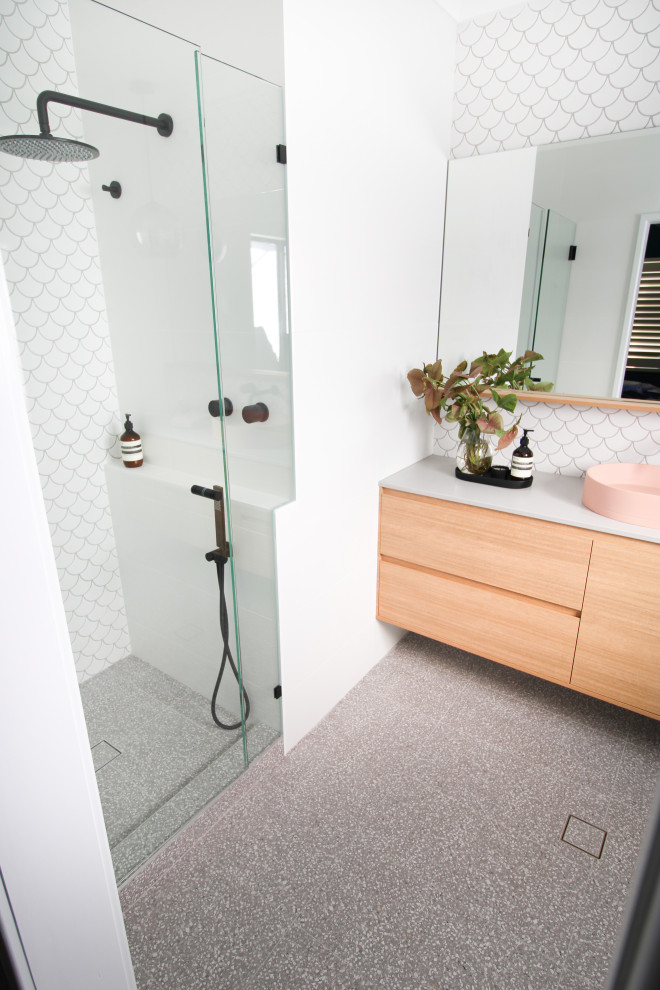 This is an example of a mid-sized modern master bathroom in Perth with furniture-like cabinets, medium wood cabinets, an alcove shower, a one-piece toilet, white tile, mosaic tile, white walls, porcelain floors, a vessel sink, engineered quartz benchtops, grey floor, a hinged shower door, grey benchtops, a shower seat, a single vanity and a floating vanity.