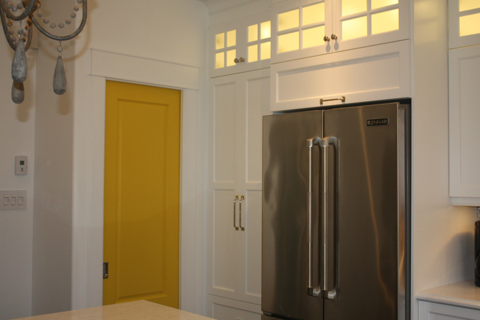 Mid-sized transitional l-shaped kitchen photo with shaker cabinets, white cabinets, white backsplash, stainless steel appliances, an island, a double-bowl sink and mosaic tile backsplash