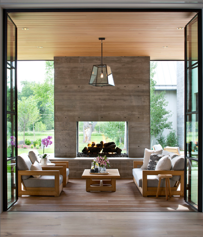 This is an example of a contemporary deck in Denver with a fire feature and a roof extension.