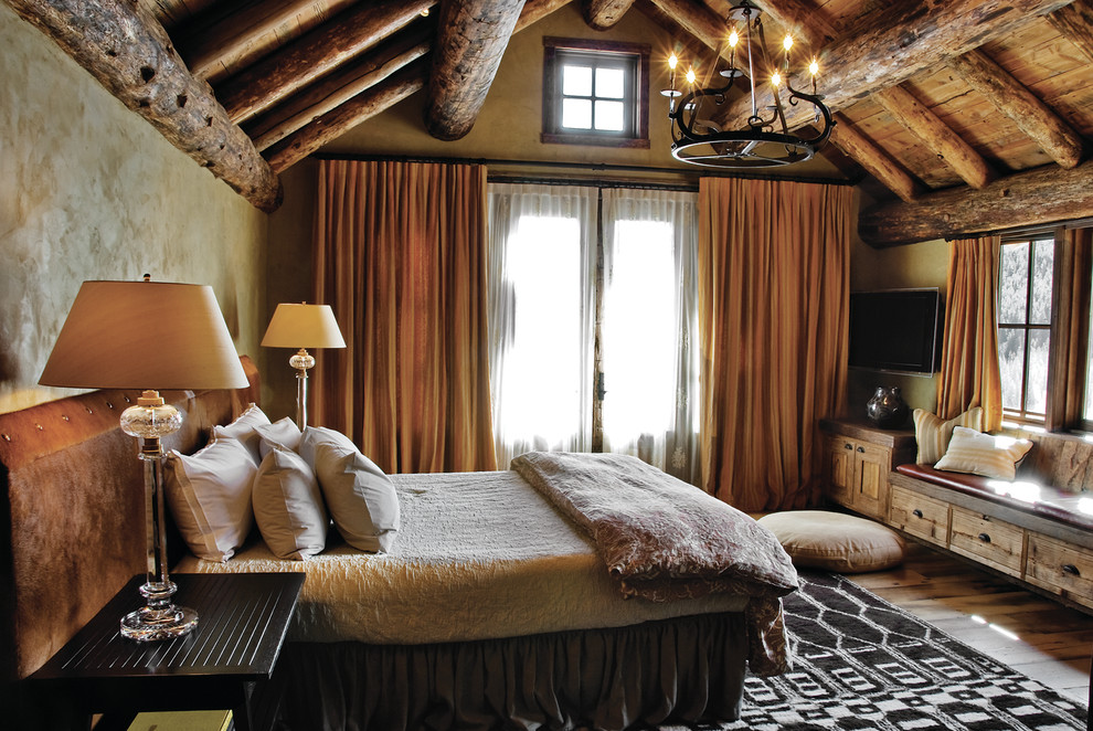 Country bedroom in Other with beige walls and medium hardwood floors.