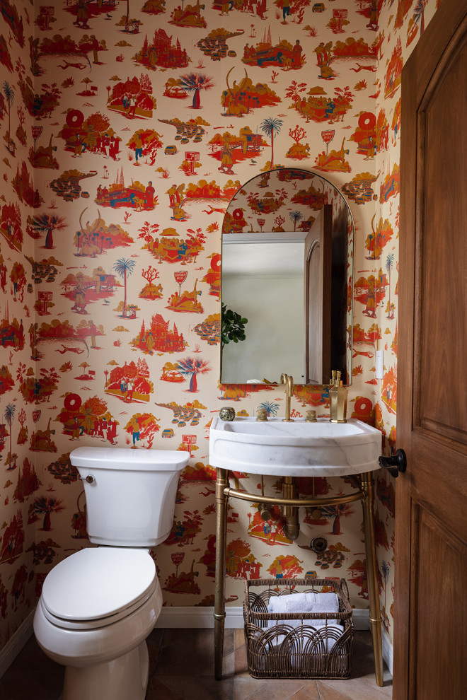 Esempio di un bagno di servizio chic con pareti multicolore, pavimento marrone e carta da parati