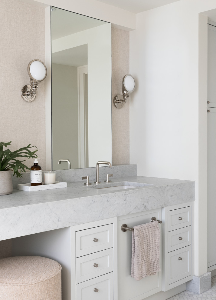 Photo of a large transitional master bathroom in Seattle with shaker cabinets, grey cabinets, an alcove shower, a two-piece toilet, white tile, ceramic tile, beige walls, marble floors, an undermount sink, marble benchtops, grey floor, a hinged shower door and white benchtops.