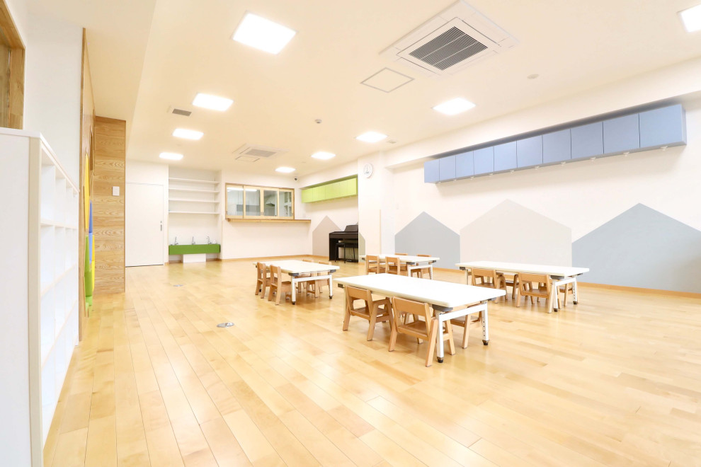 Photo of a mid-sized scandinavian gender-neutral kids' room in Nagoya with brown walls, light hardwood floors and brown floor.
