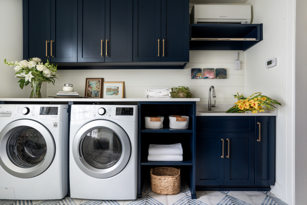 Design ideas for a large transitional galley dedicated laundry room in Nashville with an undermount sink, shaker cabinets, blue cabinets, quartz benchtops, shiplap splashback, white walls, porcelain floors, a side-by-side washer and dryer, multi-coloured floor, white benchtop and planked wall panelling.