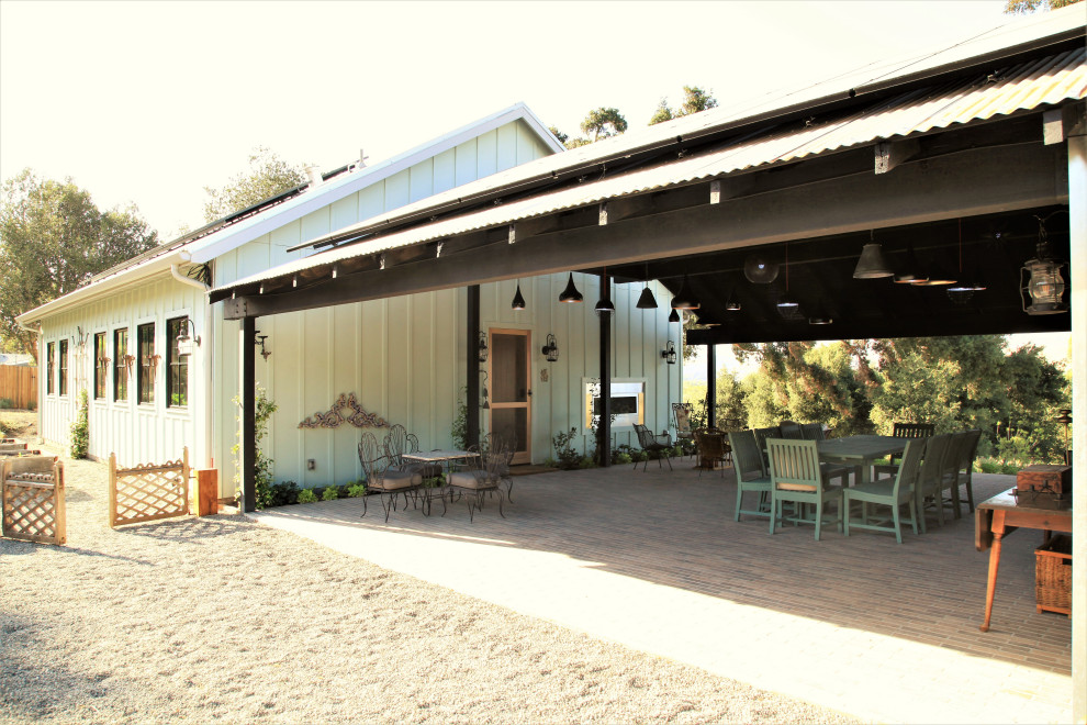 Small country blue wood and board and batten house exterior photo in Santa Barbara with a metal roof and a gray roof