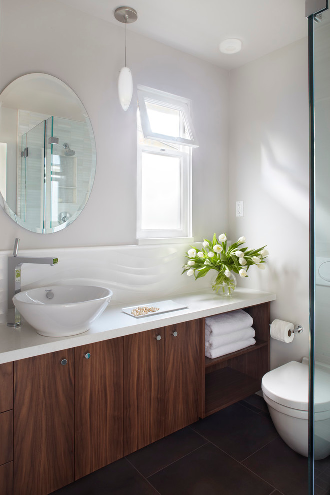 Photo of a transitional bathroom in San Francisco with a vessel sink, flat-panel cabinets, dark wood cabinets, a wall-mount toilet and white walls.