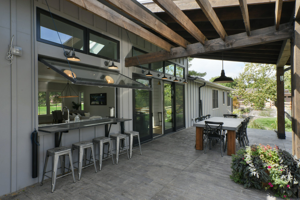 This is an example of a country backyard patio in Denver with a pergola.