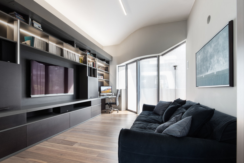 Inspiration for a contemporary enclosed living room in Milan with grey walls, medium hardwood floors, a built-in media wall and brown floor.