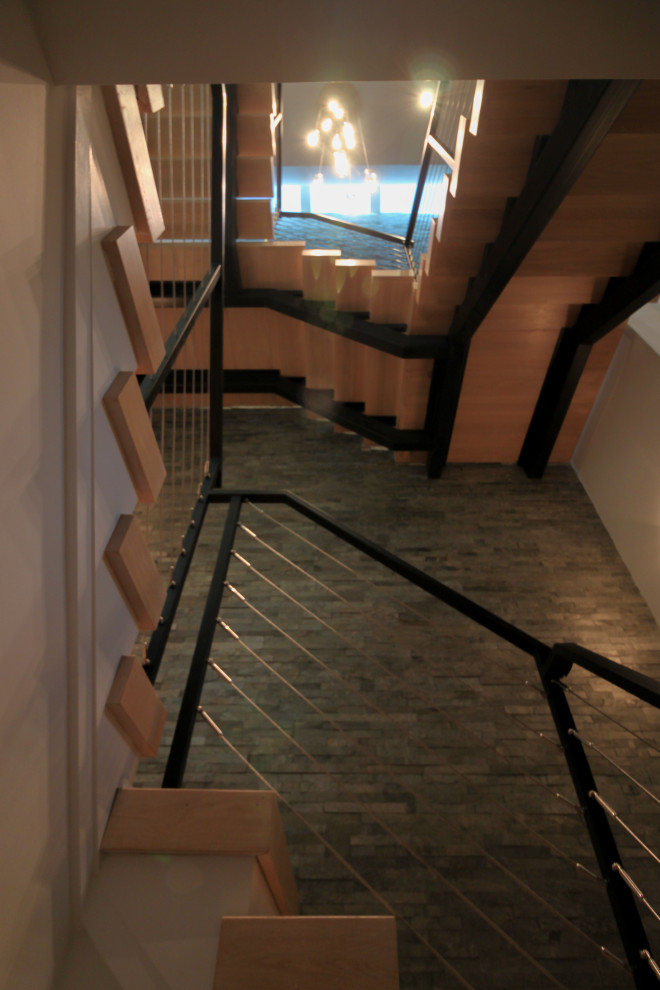 Design ideas for a large eclectic wood floating staircase in DC Metro with metal railing and brick walls.
