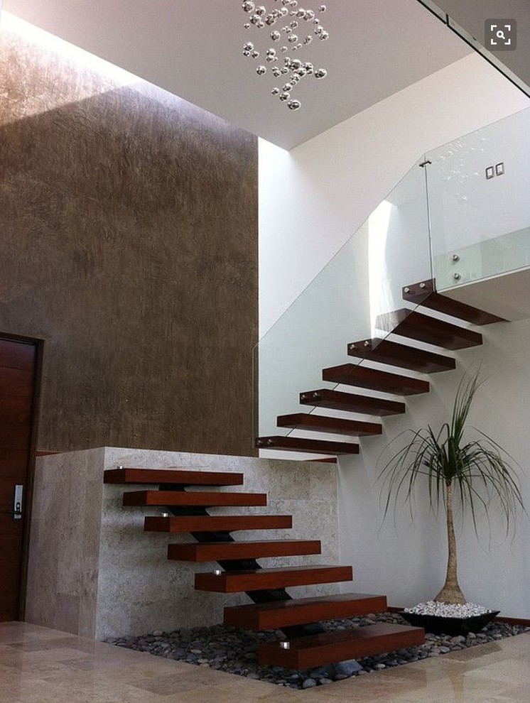 Photo of a mid-sized asian wood floating staircase in Vancouver with open risers and glass railing.