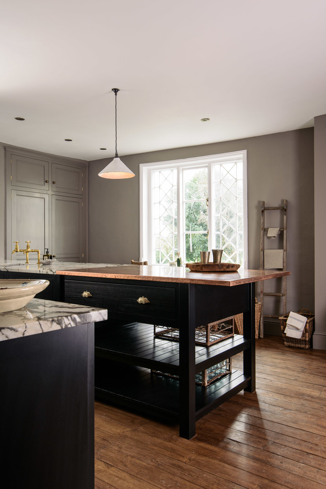 Mid-sized country single-wall open plan kitchen in Other with an integrated sink, shaker cabinets, black cabinets, copper benchtops, grey splashback, black appliances, medium hardwood floors and with island.