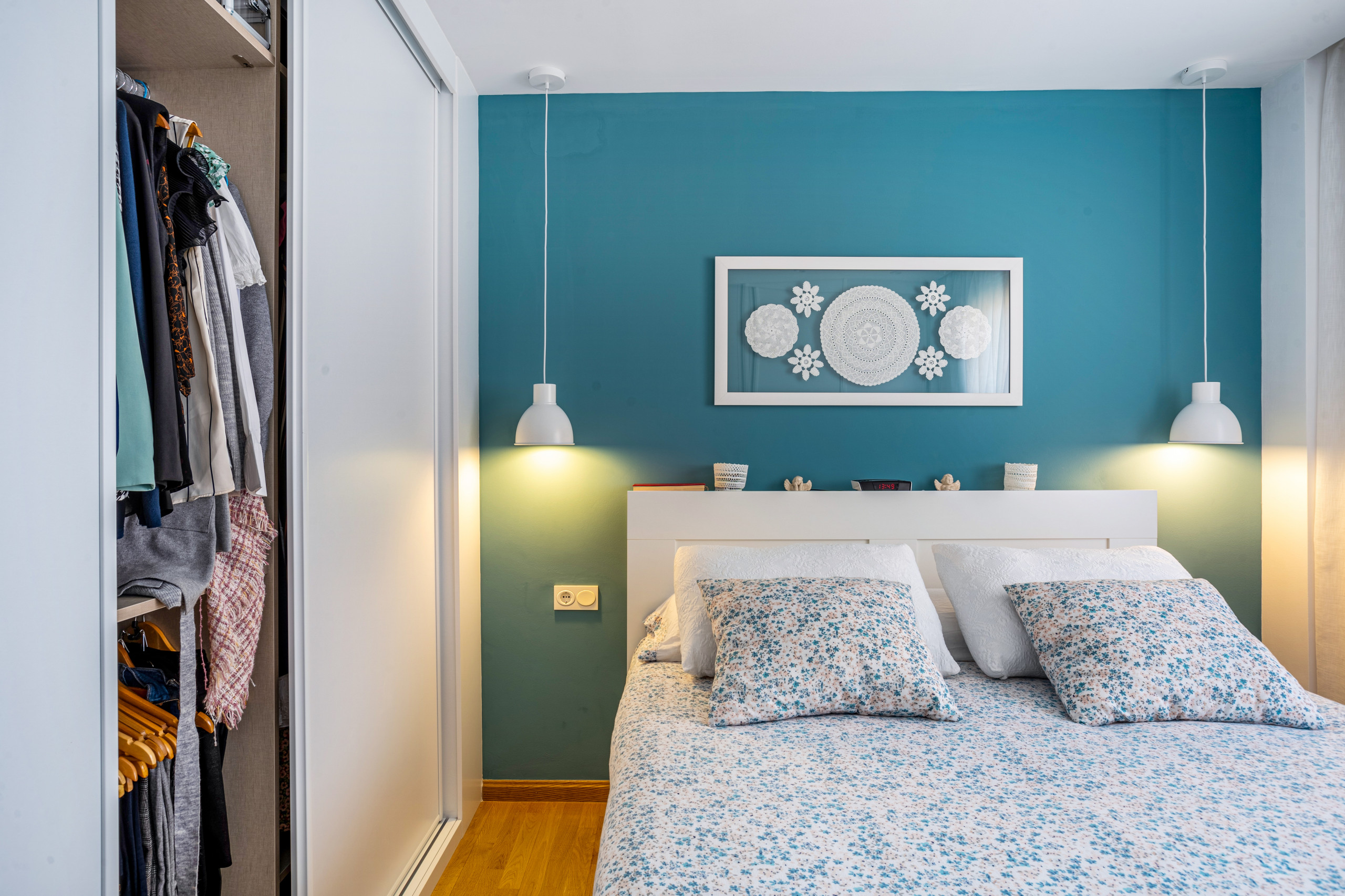 Dormitorio y vestidor con pared en color y luces suspendidas