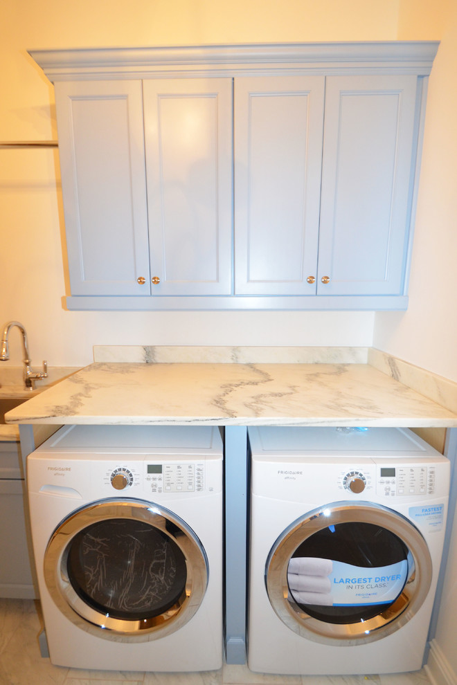 Photo of a mid-sized traditional single-wall dedicated laundry room in Louisville with an undermount sink, recessed-panel cabinets, white cabinets, quartzite benchtops, white walls, travertine floors and a side-by-side washer and dryer.