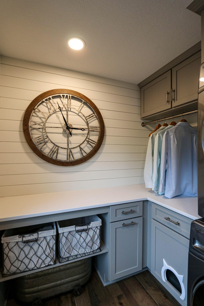 Design ideas for a small transitional u-shaped dedicated laundry room in Cleveland with recessed-panel cabinets, grey cabinets, quartz benchtops, white splashback, shiplap splashback, grey walls, a stacked washer and dryer and white benchtop.