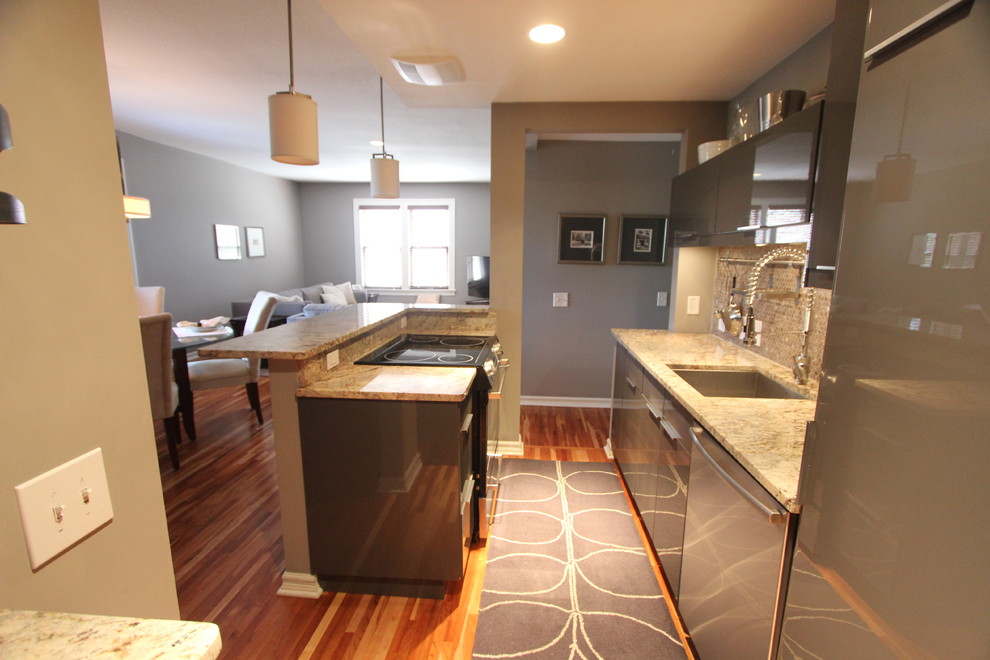 Inspiration for a small transitional galley medium tone wood floor and brown floor open concept kitchen remodel in Minneapolis with an undermount sink, flat-panel cabinets, gray cabinets, granite countertops, gray backsplash, mosaic tile backsplash, stainless steel appliances, an island and gray countertops