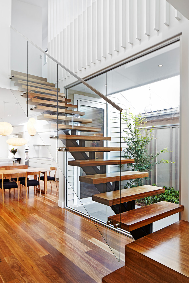 Photo of a mid-sized contemporary wood straight staircase in Melbourne with open risers.