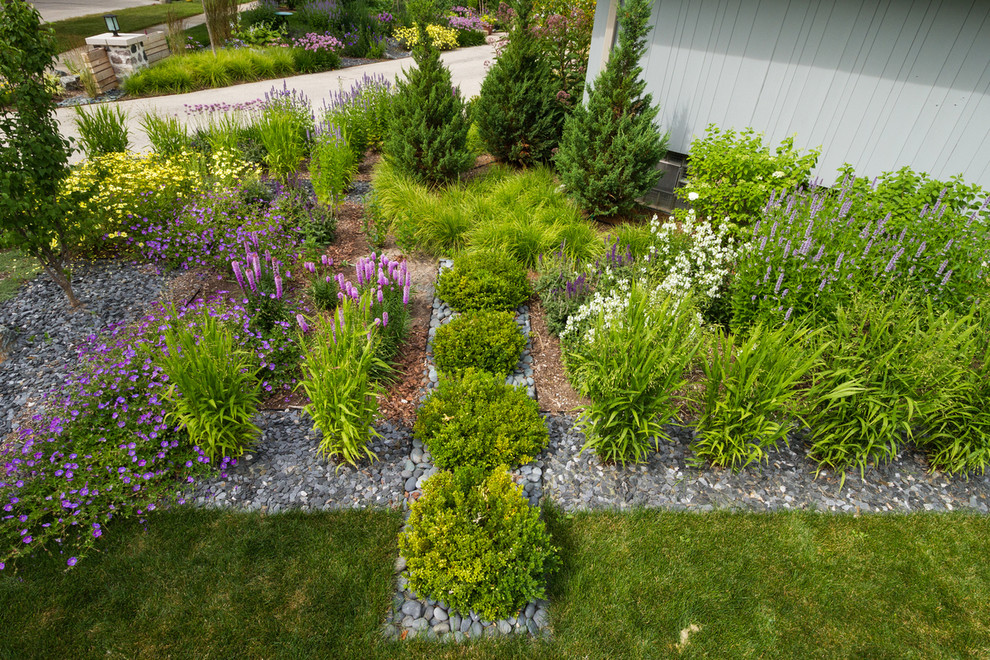 Design ideas for a mid-sized midcentury front yard partial sun driveway for summer in Milwaukee with gravel.