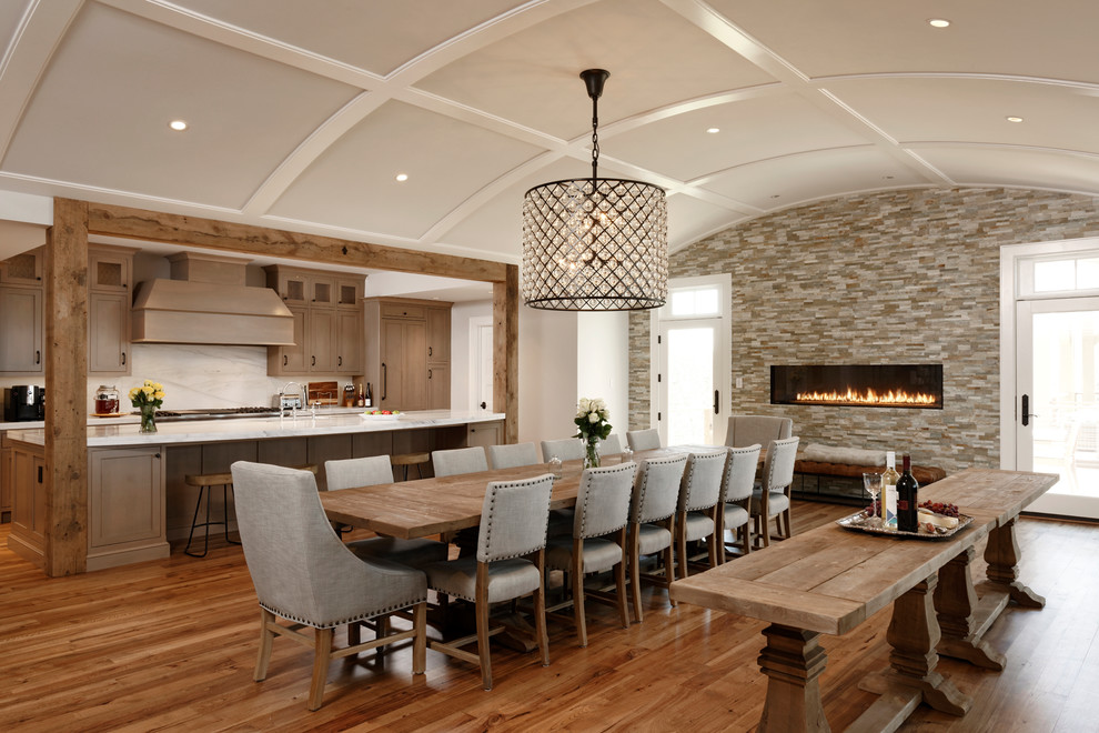 Country kitchen/dining combo in DC Metro with white walls, medium hardwood floors, a ribbon fireplace, a tile fireplace surround and brown floor.