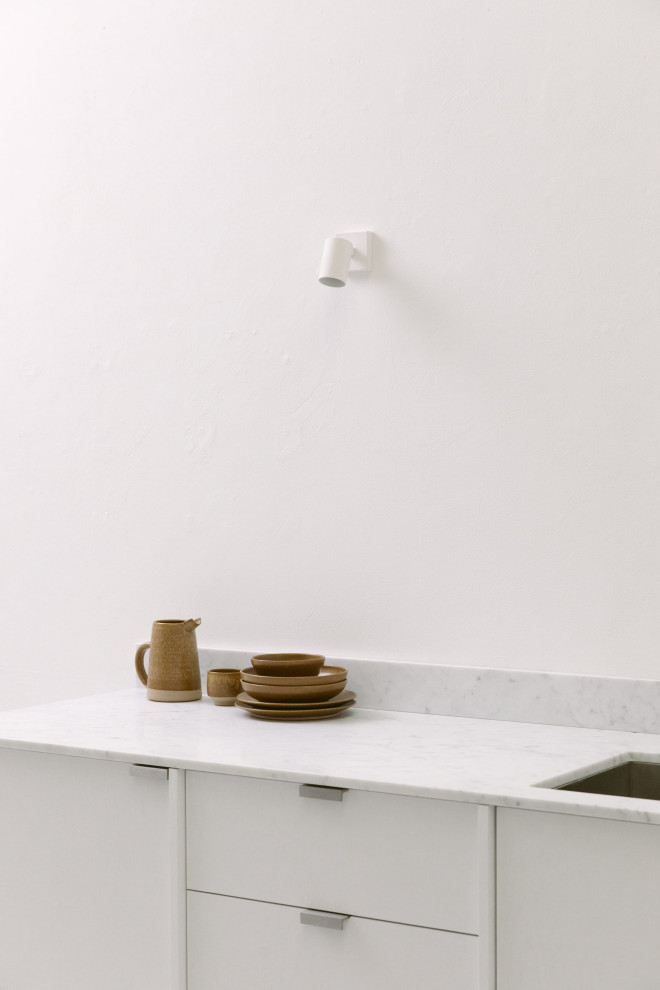 Inspiration för ett litet funkis vit vitt kök med öppen planlösning, med en dubbel diskho, släta luckor, vita skåp, marmorbänkskiva, vitt stänkskydd, stänkskydd i marmor, betonggolv och grått golv