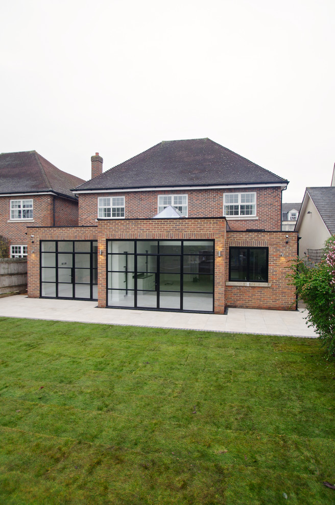 Mid-sized contemporary one-storey brick brown house exterior with a flat roof and a mixed roof.