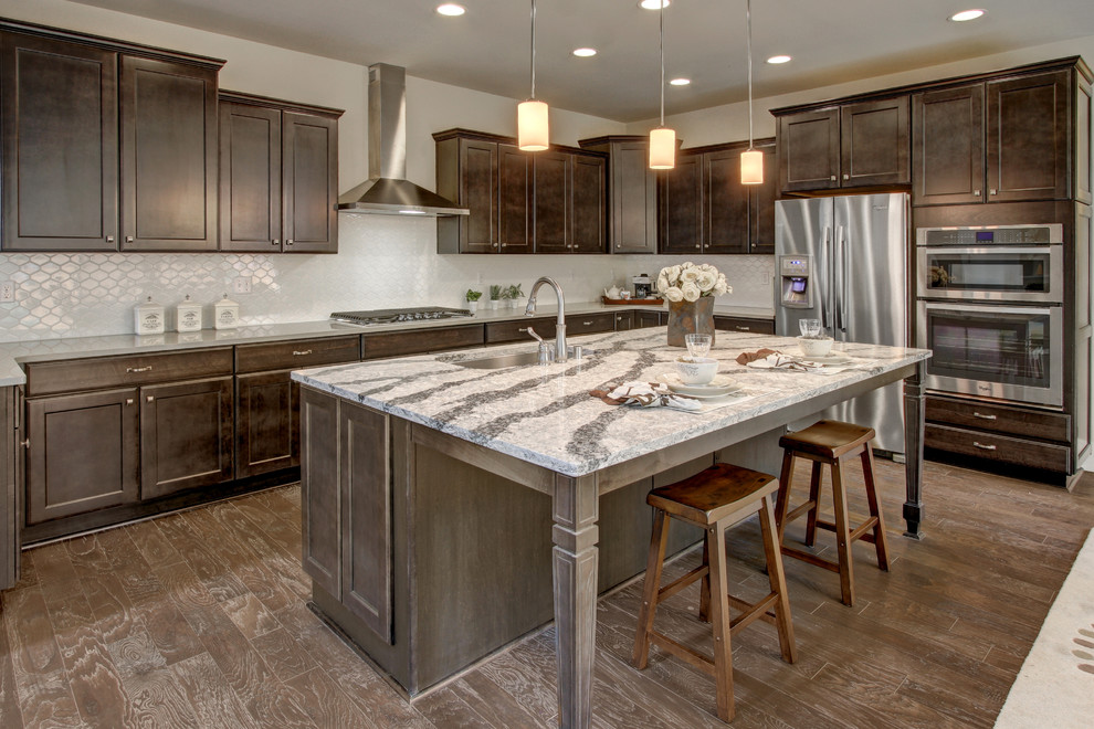 Inspiration for a transitional u-shaped open plan kitchen in Seattle with an undermount sink, recessed-panel cabinets, dark wood cabinets, quartz benchtops, grey splashback, mosaic tile splashback, stainless steel appliances, medium hardwood floors and with island.