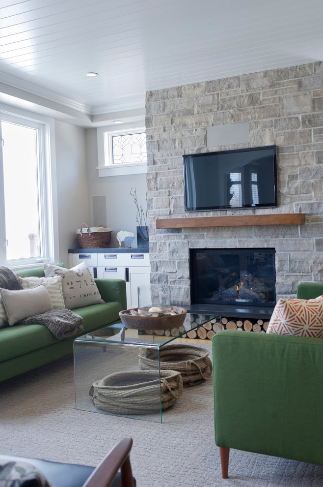Mid-sized transitional family room in Toronto with grey walls, a standard fireplace, a stone fireplace surround, a wall-mounted tv and carpet.
