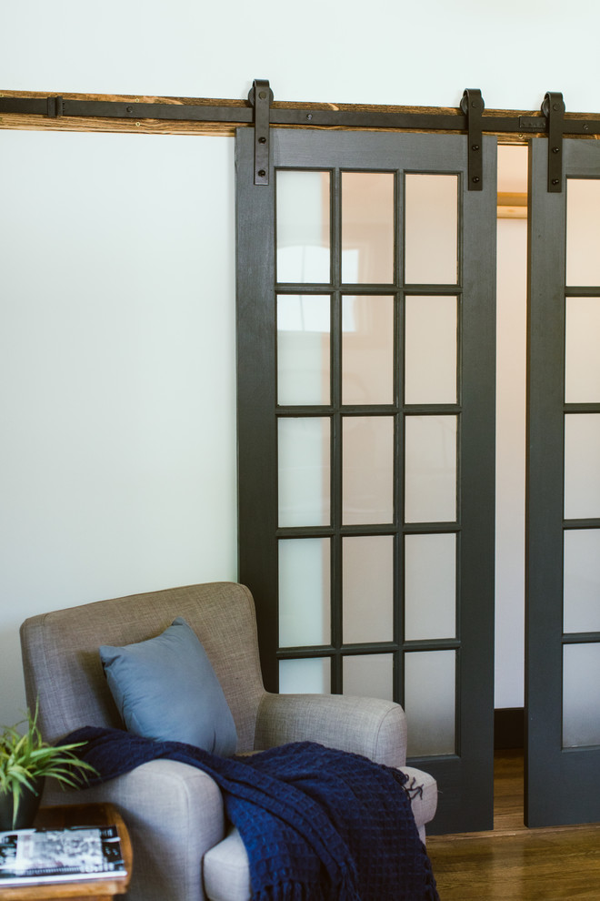 Cette image montre une chambre parentale grise et blanche minimaliste avec un mur blanc, parquet foncé, un sol marron, un plafond voûté et du lambris de bois.